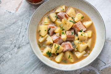 Dublin coddle or irish stew with sausage and potato, horizontal shot on a grey granite background, high angle view