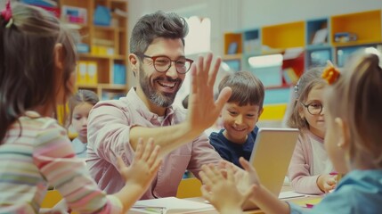 In an elementary school computer science class, the teacher uses a tablet computer to explain the lesson to a diverse group of children, giving a high five to a boy at the end.