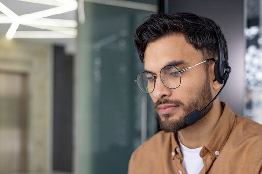 Professional man working in a call center with a headset and glasses