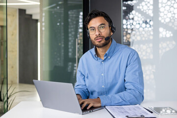 Man working remotely with headset and laptop in modern office