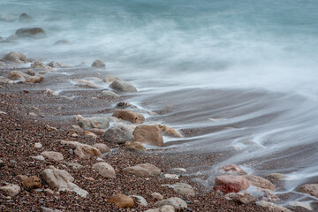 Surf with white foam on the beach, close-up. Sand coastline. Seascape for publication, design, poster, calendar, post, screensaver, wallpaper, cover, website. High quality photo