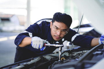 A uniformed maintenance technician is working on a vehicle inspection service. Vehicle repair and...