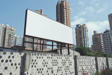 Obraz premium Unique urban backdrop featuring a tall, narrow billboard on a patterned concrete fence.