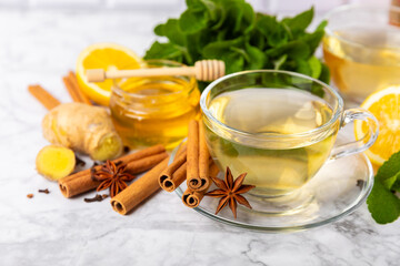 Fragrant hot tea with cinnamon stick and anise on a textured wooden background. A cup of hot tea...