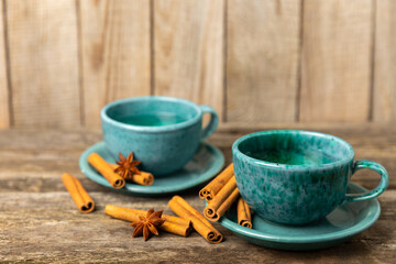 Fragrant hot tea with cinnamon stick and anise on a textured wooden background. A cup of hot tea with honey, lemon, mint and apples. Spicy tea with spices. Immunity tea. Health concept.Copy space.
