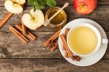 Fragrant hot tea with cinnamon stick and anise on a textured wooden background. A cup of hot tea...