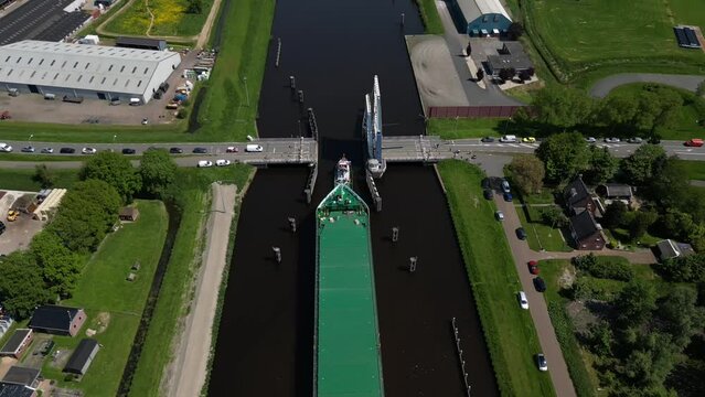 Aerial video over a river in Appingedam  Netherlands on passing cargo ships