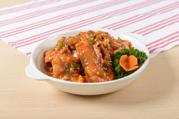 A bowl of Prawn with a green carrot on top. The food is a mix of Prawn and vegetables, and it looks delicious