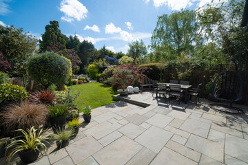 Beautiful summer garden in England, UK with lawn and large indian sandstone patio.