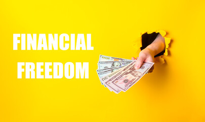 A hand holding a stack of money with the words financial freedom written below