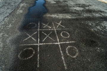 The game is tic tac toe on the asphalt.