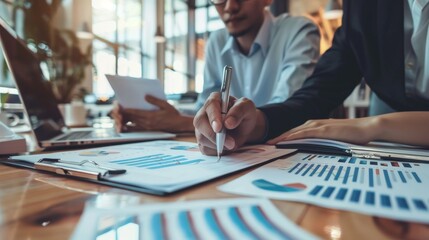 A corporate team is focused on discussing financial reports, charts, and graphs in a collaborative work environment