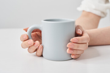  	マグカップを持つ女性の手元