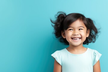 Cyan background Happy Asian child Portrait of young beautiful Smiling child good mood Isolated on...