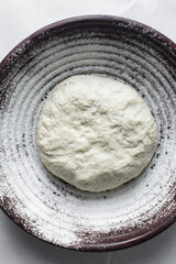 Overhead view of bread dough rising in banneton basket , top view of proofing dough in a wood...