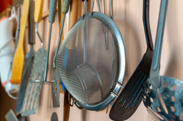 A collection of kitchen utensils including a spatula, a whisk, and a strainer