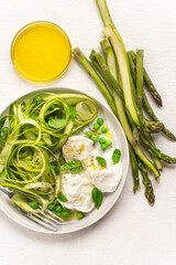 Salad with fresh asparagus, green peas, aromatic herbs with Bufala mozzarella. Healthy summer and spring lunch Mediterranean and French cuisine, balanced nutrition. White background