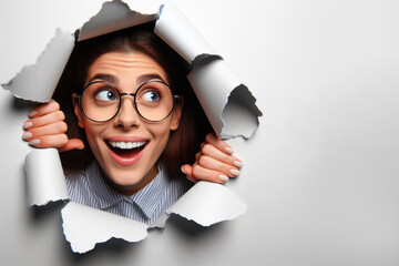 funny woman peeking out of hole in paper wall Isolated on white background