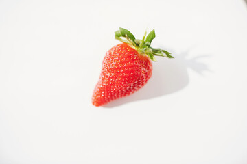 A close-up picture of a bright one red strawberry or berry as a fruit or food. An isolated white background is a naturally fresh fruit. red strawberry, selective focus.