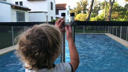 Child trying to open swimming pool safety fence