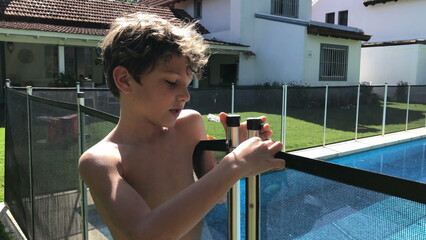 Child wanting to open swimming pool protection safety fence