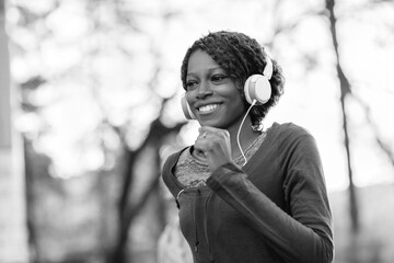 Smiling young woman jogging outside with headphones