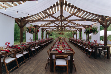 wedding holiday banquet in the open air. covered, served tables in the yard, garden in nature. wooden tent covered with fabric, wedding banquet