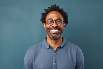 Obraz premium Portrait of a joyful afro-american man in his 40s smiling at the camera in front of blank studio backdrop