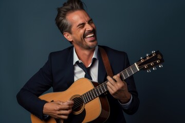 Naklejka premium Portrait of a satisfied man in his 40s playing the guitar in front of blank studio backdrop