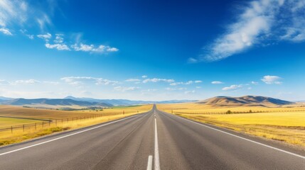 Fototapeta premium A straight, empty road stretching into the distance with a clear arrow pointing forward, surrounded by golden fields and rolling hills under a bright blue sky The image captures the essence of freedom