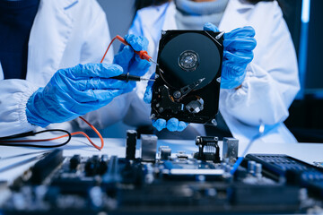 Technician repairing inside of hard disk drive by screwdriver. the concept of data, hardware,...