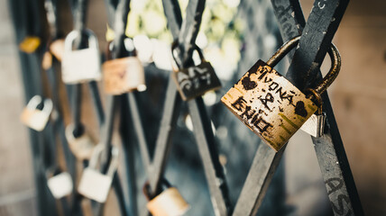 Vintage locks in soft focus as a symbol of love for friends and lovers. Padlocks are attached to...