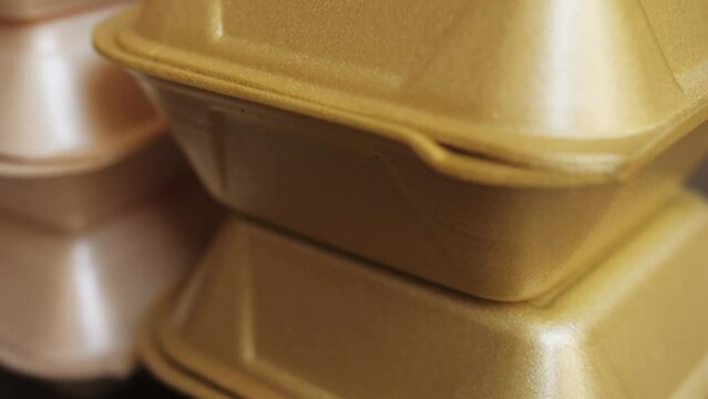 Takeaway boxes, foam boxes, rectangular shaped clamshell style container with an attached lid. Concept: single use containers.