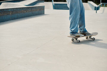 A young skater boy confidently riding his skateboard on top of a cement ramp at a bustling outdoor...