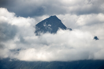 Clouds cover the peaks of the mountains. View of the Caucasus Mountains in Ingushetia, Russia
