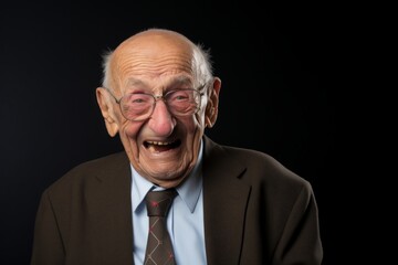 Portrait of a glad elderly man in his 90s laughing in blank studio backdrop