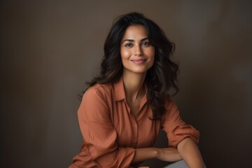 Portrait of a blissful indian woman in her 30s with arms crossed isolated in light wood minimalistic setup