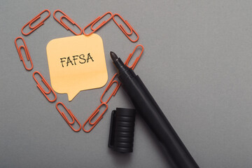 A pen with a piece of paper with the word FAFSA written on it