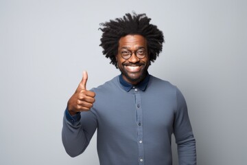 Portrait of a content afro-american man in his 40s showing a thumb up in light wood minimalistic setup