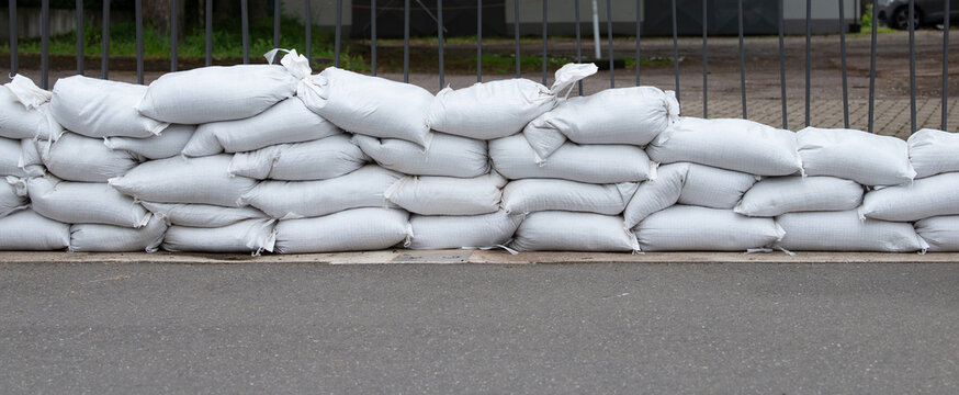 Sandbags for flood defense, river Moselle Trier in Rhineland Palatinate, flooded trees and paths, high water level, climate change