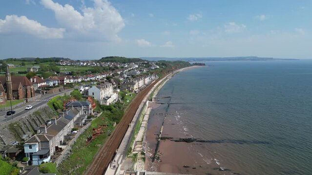Dawlish, South Devon, England: DRONE VIEWS: The coastline at Dawlish featuring the railway track and station, the beach, sea, houses and town quay. Dawlish is a popular UK holiday resort (Clip 1).