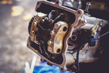 The mechanic is setting the valve on the motorcycle engine.	