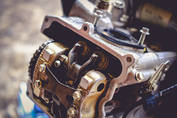 The mechanic is setting the valve on the motorcycle engine.	