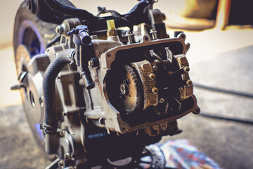 The mechanic is setting the valve on the motorcycle engine.	