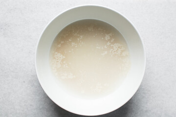 Instant dry yeast sprinkled on warm water, dry yeast granules on water