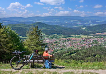 active senior woman on a bike packing tour with her electric mountain bikeup to the summit of Great...