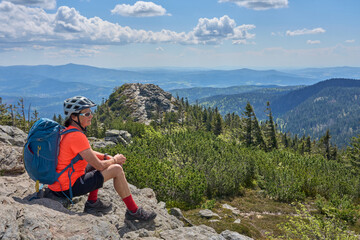 active senior woman on a bike packing tour with her electric mountain bike in the rocky  the summit...