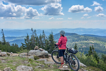 active senior woman on a bike packing tour with her electric mountain bike in the rocky  the summit...