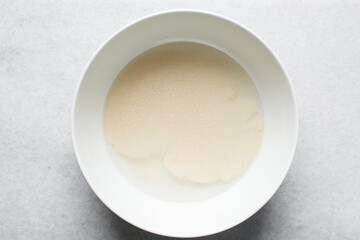 Instant dry yeast sprinkled on warm water, dry yeast granules on water