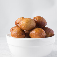 Overhead view of nigerian puff-puff on a white plate, nigerian fried dough balls, flatlay of...